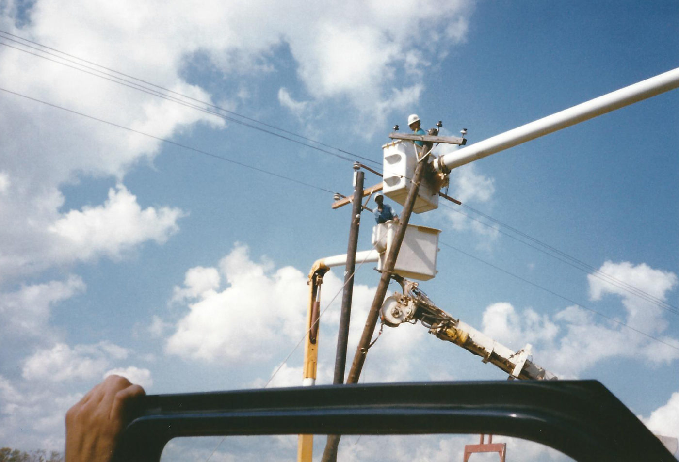 Electrician on a lift truck working on power poles.
