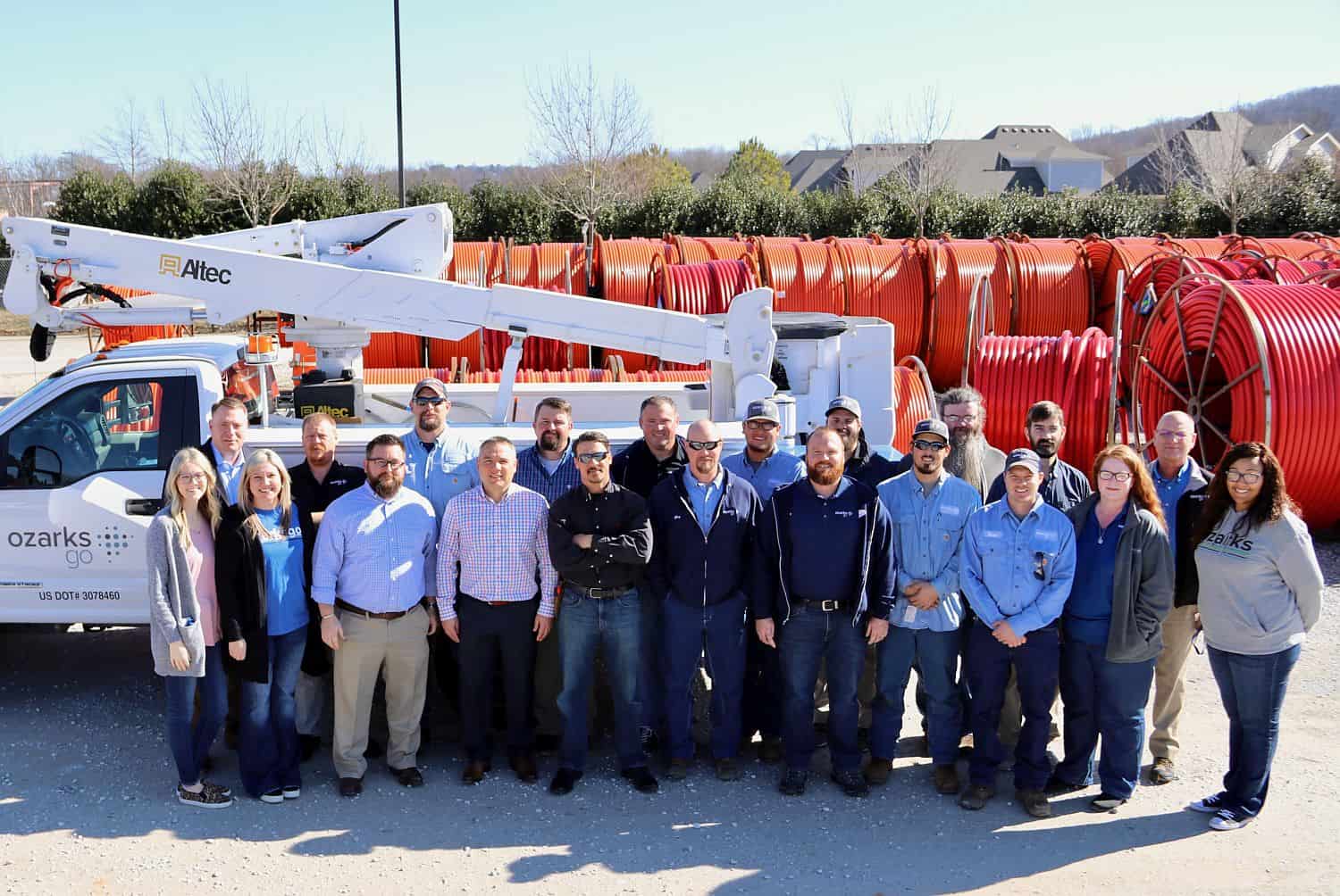 Ozarks Go employee group photo in front of a lift truck and fiber cables.