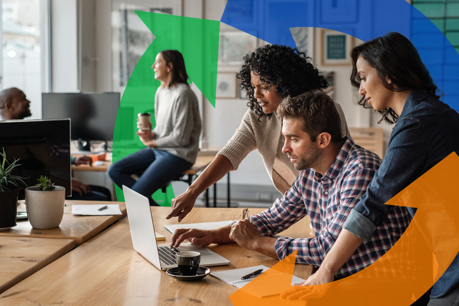 Co-workers stand over a man using the computer helping to direct information with a Conexon logo behind for thumbnail