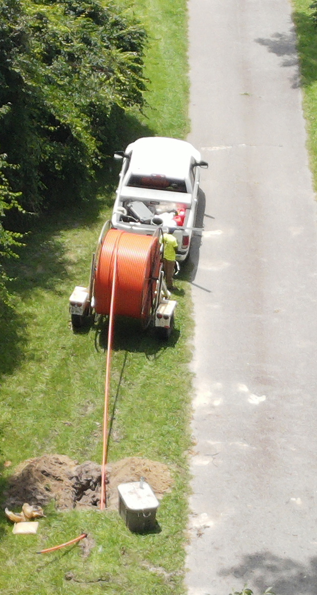 A arial shot of a fiber cable truck dispensing cable underground.