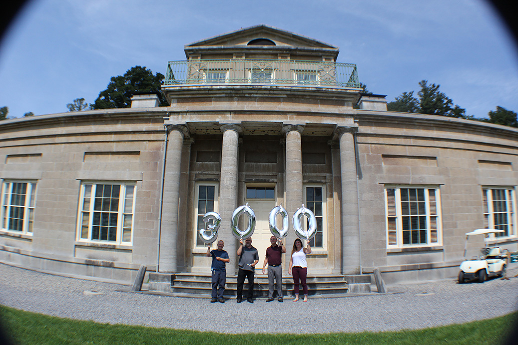 OEConnect outside building holding balloons that spell 3000.