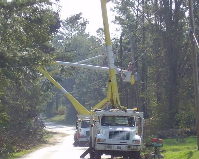 Lift trucks on the side of the road with arms extended.