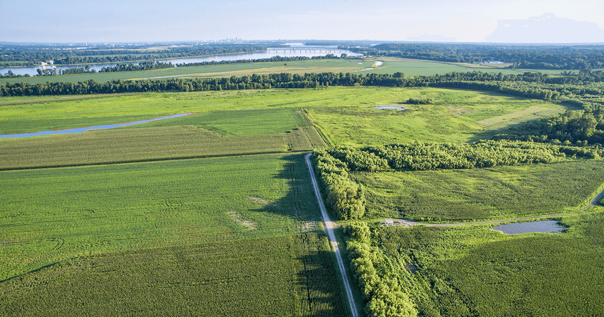 Arial shot of farmland fields with ponds and a river.