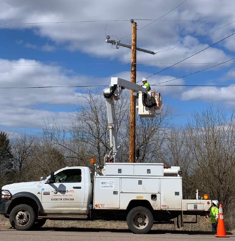 Lift truck hoisting an electrician up to a power pole.