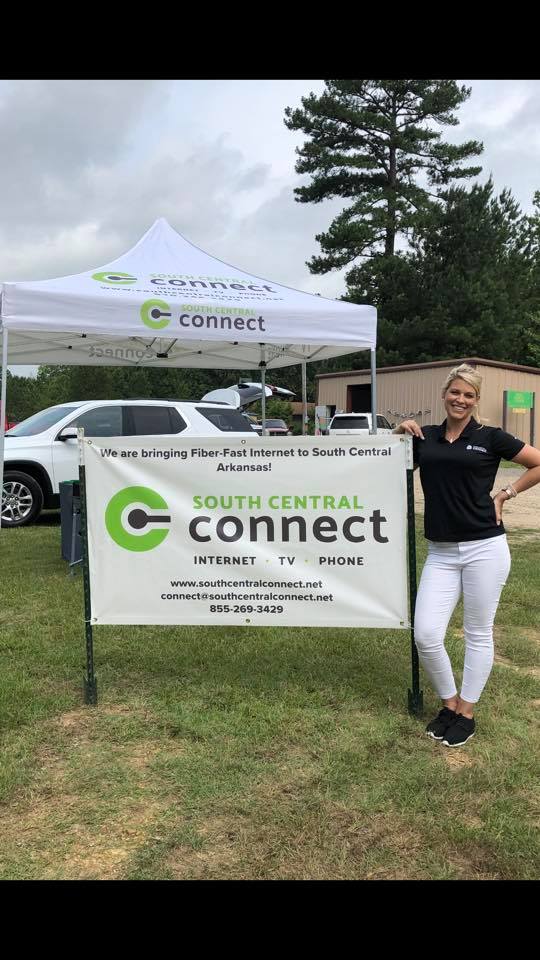 A woman leans on a sign that says South Central Connect.