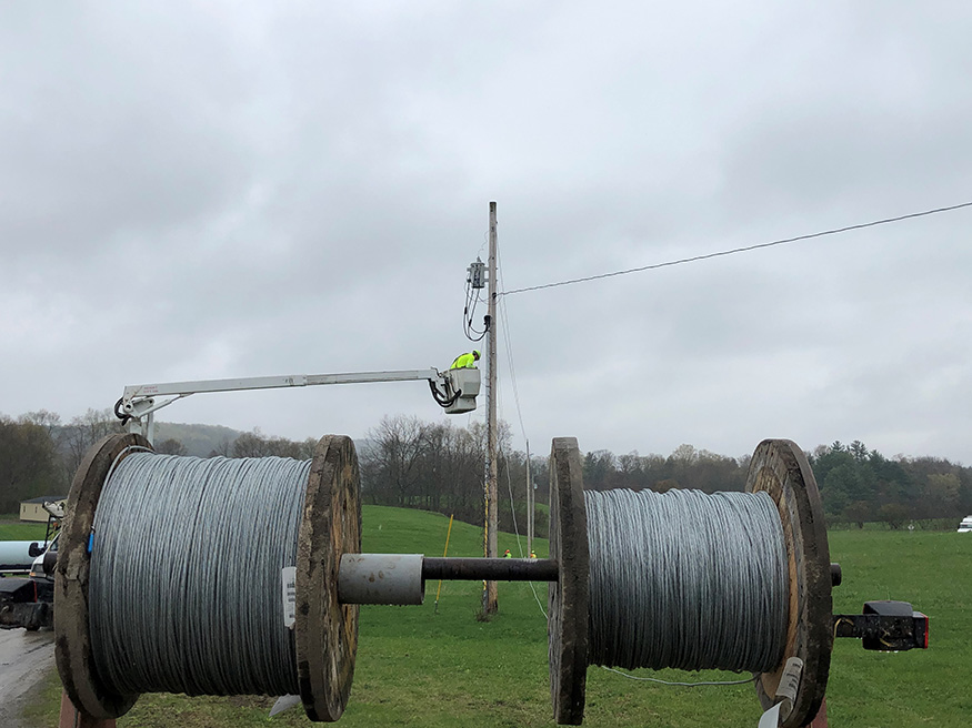 Two massive wire rolls with a boom truck in the background.
