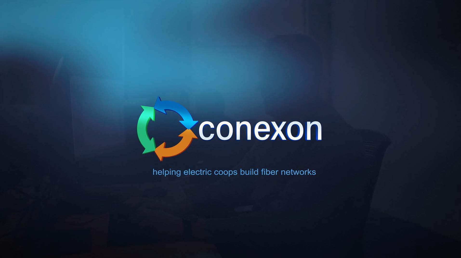 A man sitting at his computer desk with a blue gradient over top with the Conexon logo in the middle.
