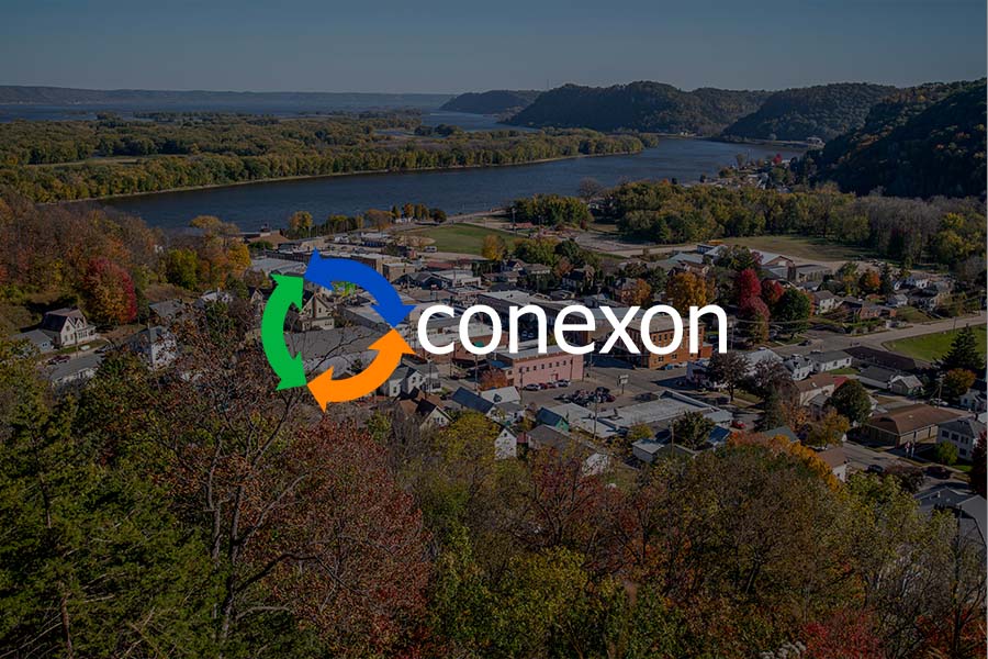 Arial view of a small mid-western town with a river in the background and a Conexon logo over dark background..