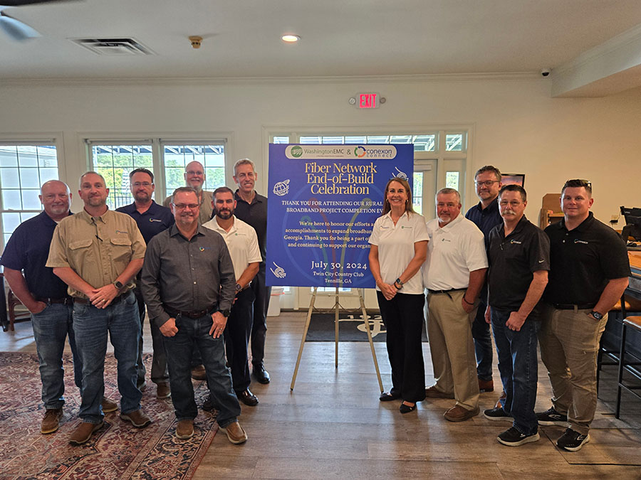 The larger Washington EMC taking a group shot in front of a banner.