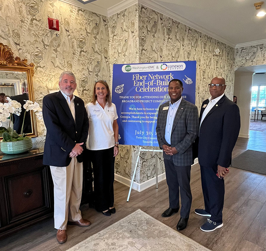 The Washington EMC team taking a group shot in front of a sign.